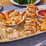 Shrimp Your Way Choose Four seafood combo with garlic shrimp, Cajun shrimp, crispy shrimp, biscuits, and side dishes