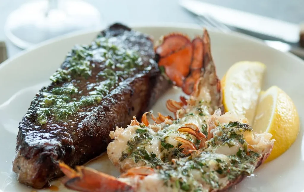 surf and turf seafood platter with lobster tail steak shrimp and mashed potatoes