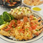 Grilled Lobster, Shrimp and Salmon platter served with garlic butter, lemon, and two side dishes