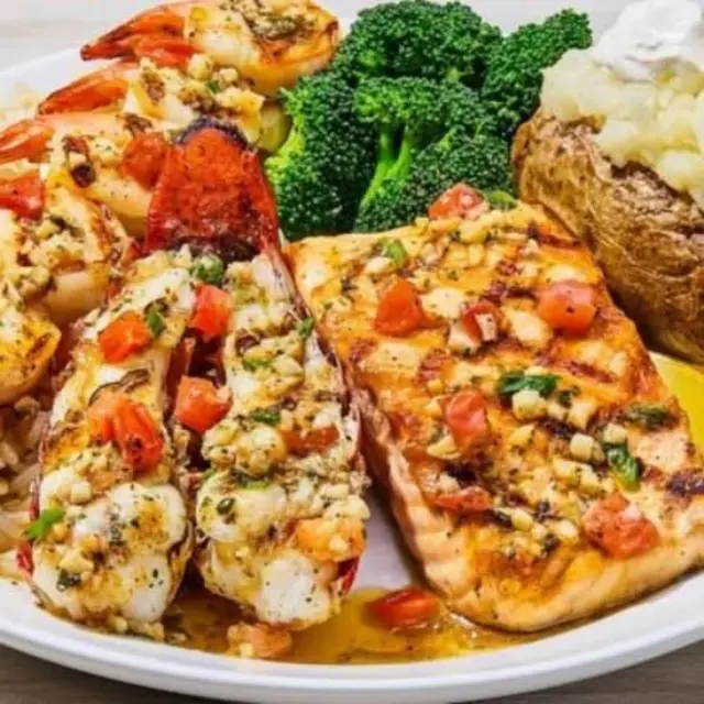 Close-up of Grilled Lobster, Shrimp and Salmon with melted garlic butter and grilled vegetables