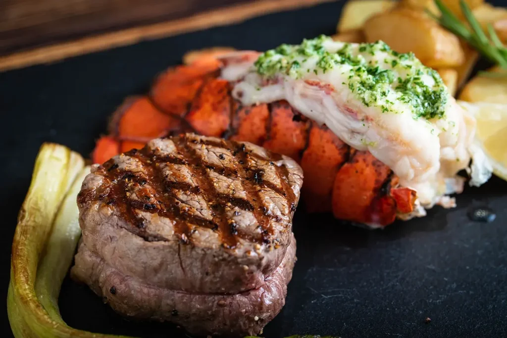 Red Lobster Surf & Turf Maine Lobster Tail & 7 oz. Sirloin served with a side dish and Cheddar Bay Biscuits.