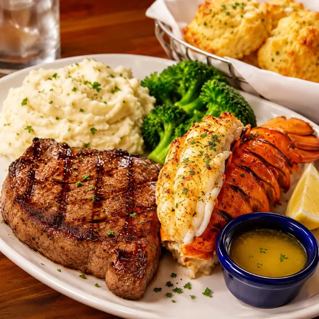 Red Lobster Surf & Turf Maine Lobster Tail with a grilled 12 oz. New York Strip steak served with two side dishes and Cheddar Bay Biscuits.