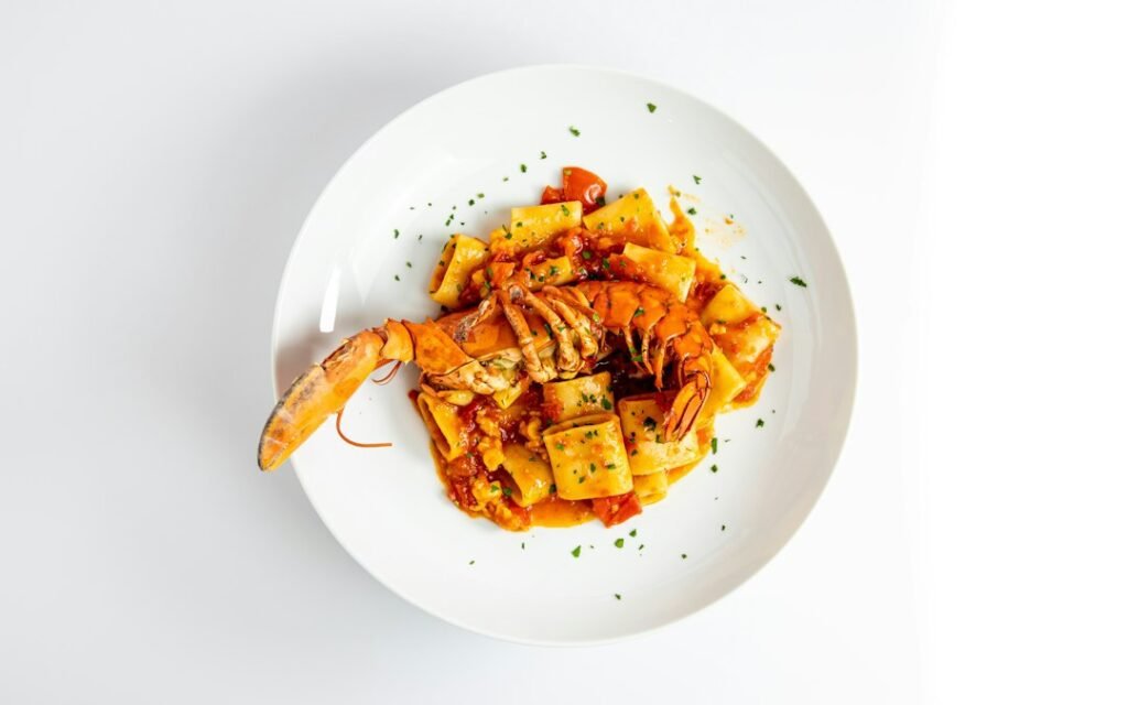 Lobster pappardelle pasta with shrimp served on a white plate